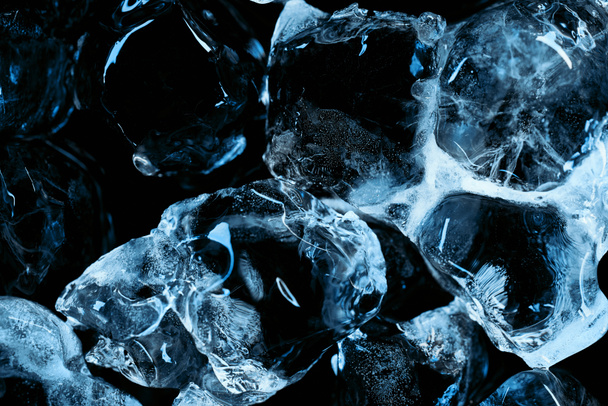 frozen transparent ice cubes with blue lighting isolated on black - Foto, afbeelding