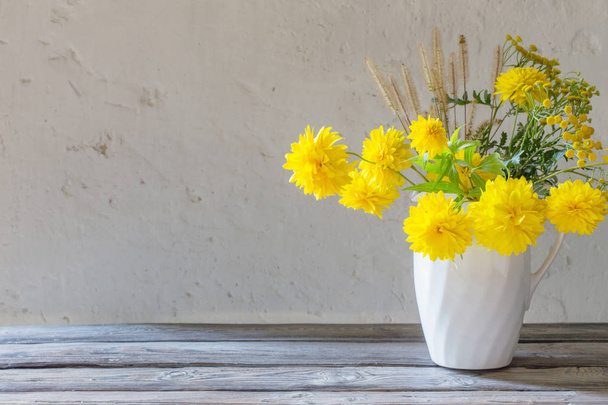 yellow summer flowers in jug on white background - Foto, Imagen