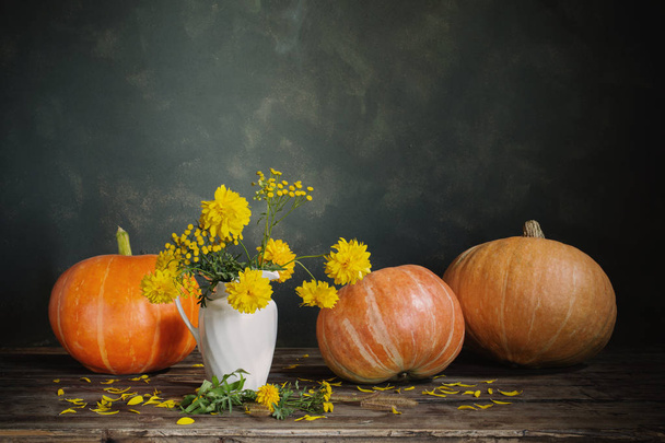 still life with yellow flowers and pumpkins on old wooden table  - Foto, Bild