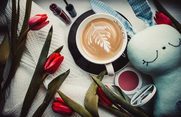 Tasse de café, jouet et fleurs sur un fond en bois - Photo, image