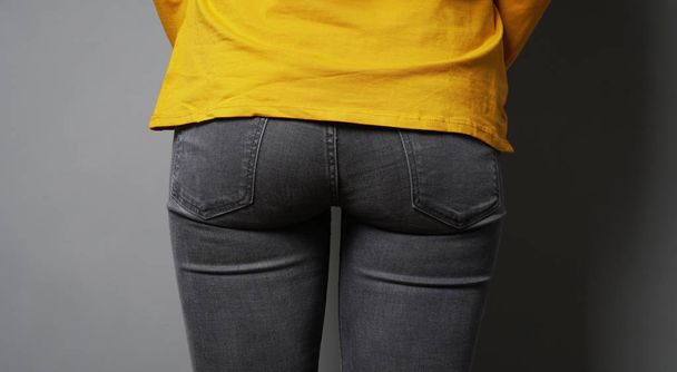 female butt or bottom wearing black denim jeans - Fotografie, Obrázek