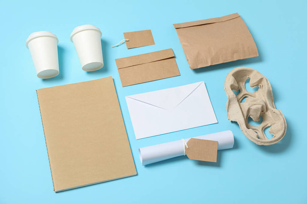 Σύνθεση με χάρτινες κούπες και προμήθειες γραφείου σε μπλε προγρού - Φωτογραφία, εικόνα