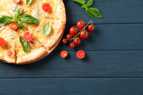 Pizza de queso con tomates y albahaca sobre fondo de madera, copiar
  - Foto, imagen