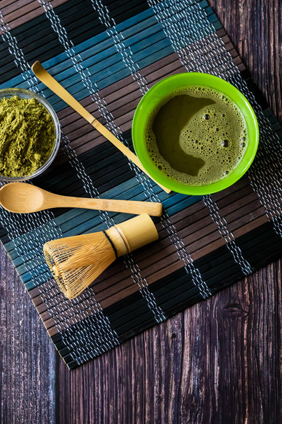 matcha of green tea in a bowl on a wooden surface. Top view, contains antioxidants, detox. Vertical orientation - Zdjęcie, obraz