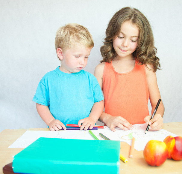 jongen en meisje tekenen met kleurrijke potloden. - Foto, afbeelding