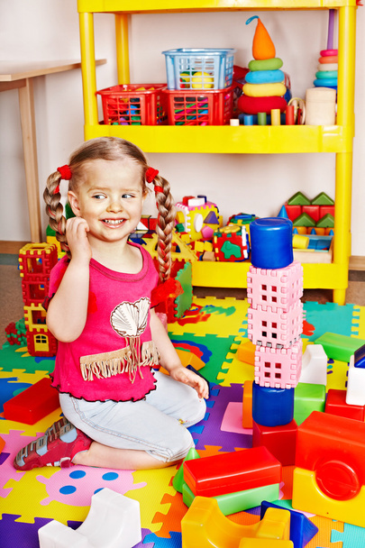 Child with puzzle, block and construction set in play room. - Photo, Image
