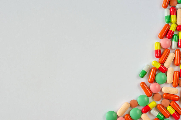 Heap of multi-colored pills, tablets and capsules on a white background. Closeup of medicines. Copy space. Top view - Foto, afbeelding