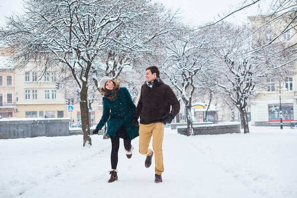 Ekose eşarplar giymiş genç seven çift kışın eski şehirde yürümek. erkek ve kadın rahat tarzı - Fotoğraf, Görsel