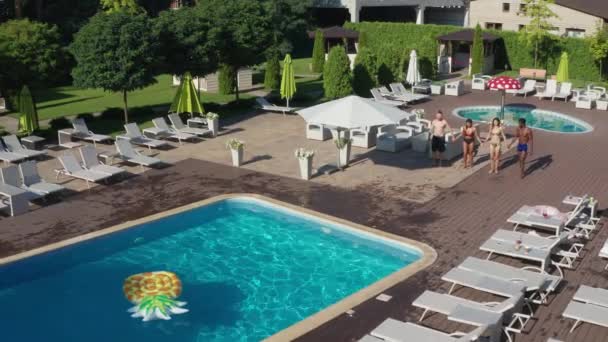 Foto aérea de amigos multirraciales saltando en la piscina
 - Imágenes, Vídeo