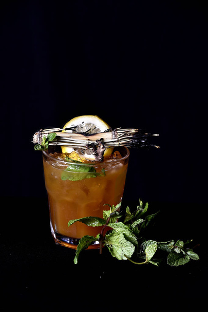 Exotisches und alkoholisches Getränk mit Früchten auf schwarzem Hintergrund - Foto, Bild