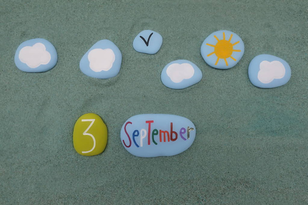 3. September, Kalenderdatum mit roten Buchstaben und Zahlen aus Stein über grünem Sand - Foto, Bild