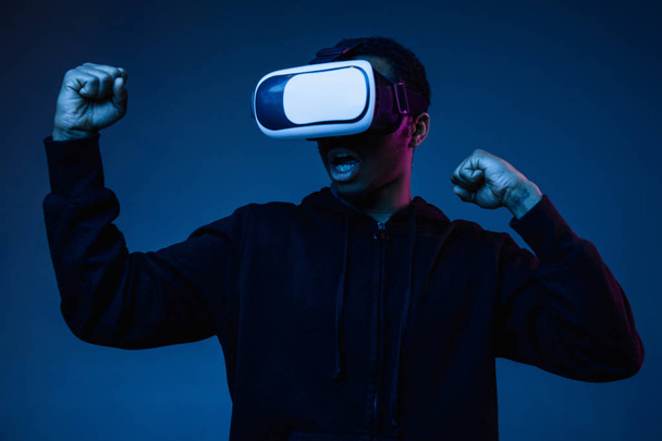 Young african-american mans using VR-glasses in neon light - Foto, Bild