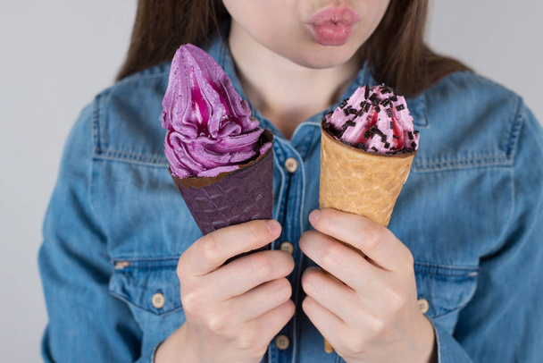 I adore candies concept. Cropped close up photo of satisfied excited dreamy cheerful lady choosing two objects to eat pink violet color jeans casual hipster shirt isolated grey background - Photo, Image