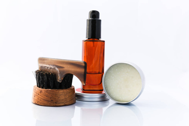 Uma seleção de produtos de limpeza de barba masculina que incluem óleo, cera e uma escova, tiro contra um fundo branco limpo
 - Foto, Imagem