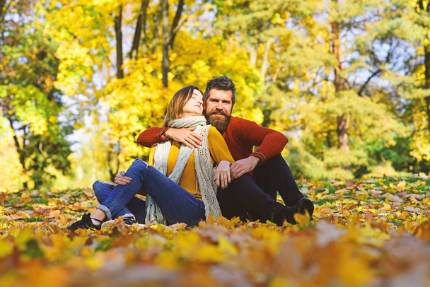 Man and woman with romantic faces on autumn trees background - Photo, Image
