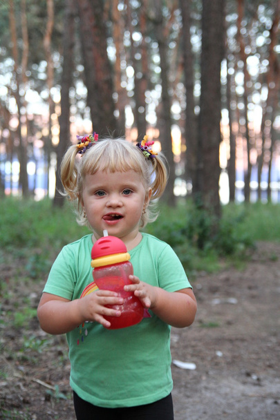 Little girl drinking from plastic bottle - Foto, imagen