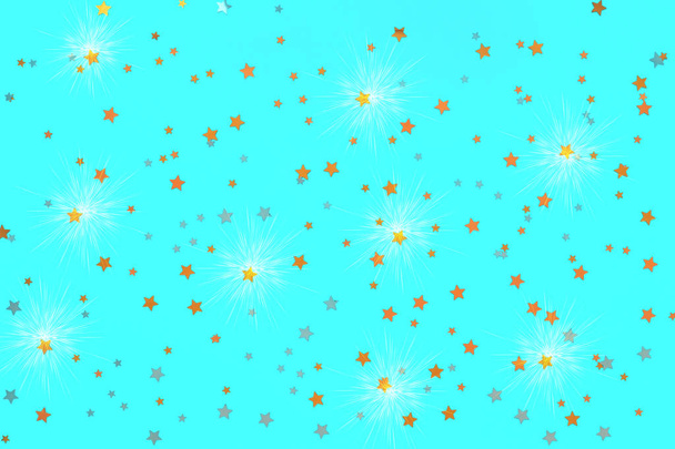 Zdjęcie złote gwiazdki konfetti posypki na niebieskim tle z efektem połysku. Świąteczne tło wakacji dla Twoich projektów. Koncepcja obchodów. Wzór świąteczny. Widok z góry - Zdjęcie, obraz