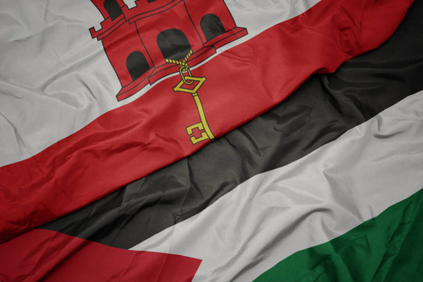 acenando bandeira colorida da Palestina e bandeira nacional de gibraltar
. - Foto, Imagem