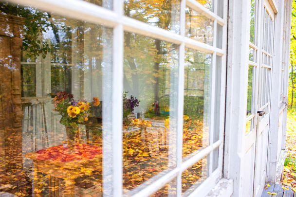Reflection of autumn park in glasses summer terrace - Foto, imagen