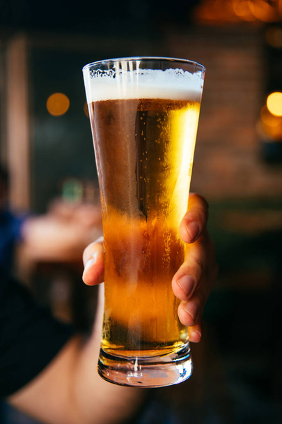Mann mit kaltem Bierglas in der Hand. Erfrischung kaltes Lagerbier - Foto, Bild