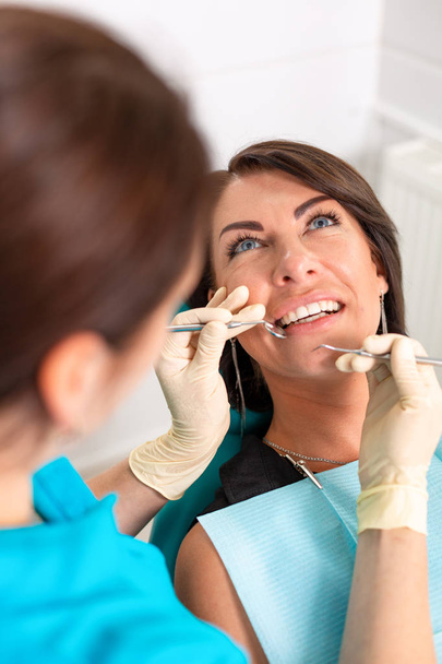 Niesamowity uśmiech widok z góry dentysta bada jego piękny pacjenta w biurze dentysty - Zdjęcie, obraz