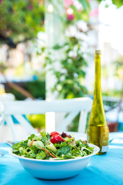 Fish Restaurant'ta yunan, akdeniz veya ege yeşili taze vejetaryen salatası masaya yatırıldı. Yunanistan veya Türkiye'deki Beach Fish Restaurant'ta zeytinyağlı kasede Yeşil Salata. - Fotoğraf, Görsel