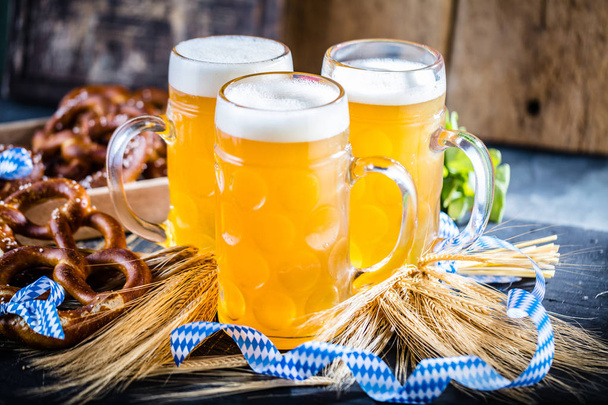 close-up view of fresh cold beer and pretzels on table, oktoberfest concept - Fotoğraf, Görsel