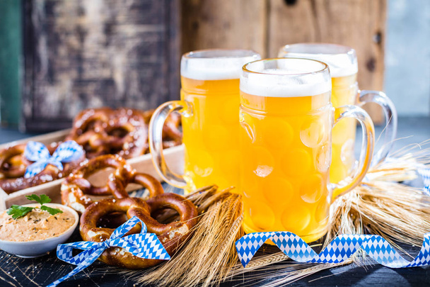 close-up view of fresh cold beer and pretzels on table, oktoberfest concept - Foto, Imagem