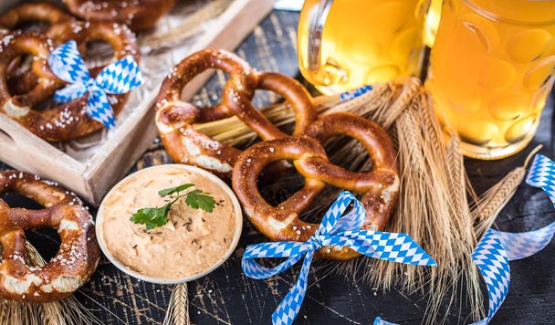 close-up view of fresh cold beer and pretzels on table, oktoberfest concept - Photo, image
