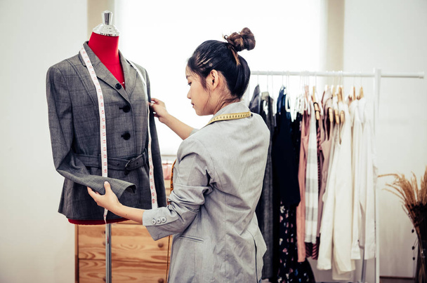 Asian female fashion designer girl making fit on the formal suit - Фото, изображение