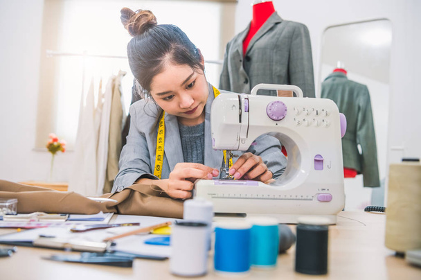 Attractive female fashion designer hand working in workshop with - Фото, изображение