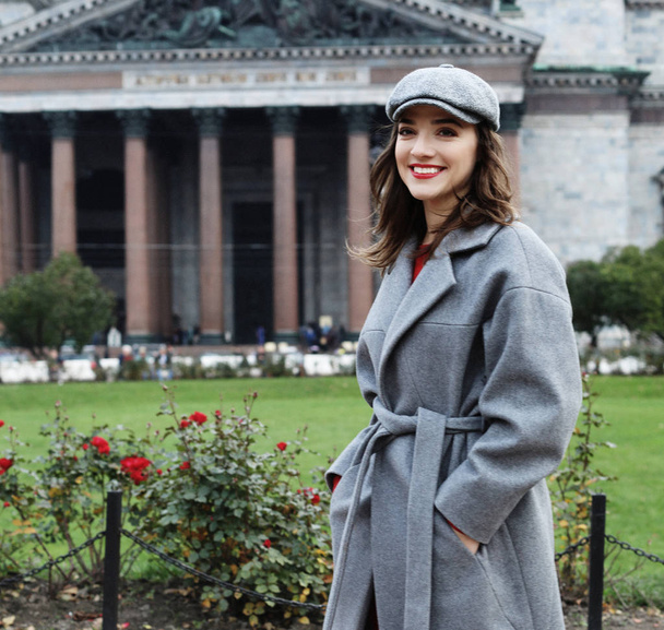 Outdoor photo of fashionable female model with hat walking around city in autumn vacation. - Fotó, kép