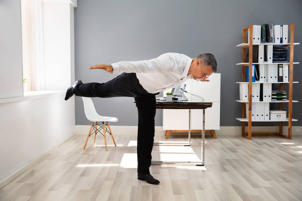 Happy Businessman Doing Stretching Exercise In Office - Foto, immagini