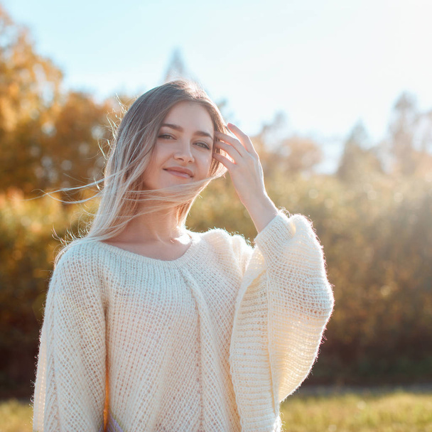 カメラでポーズをとり、晴れた秋の日を楽しむかわいい女の子. - 写真・画像