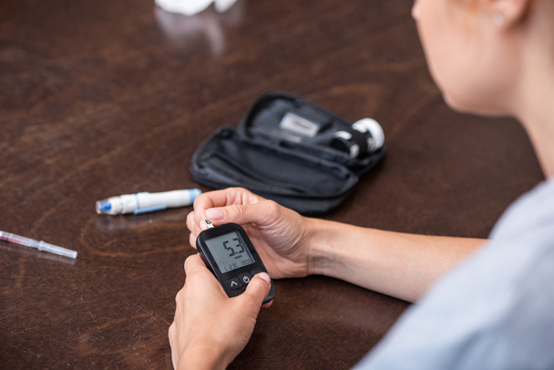 selective focus of woman holding glucose monitor at home  - Photo, Image