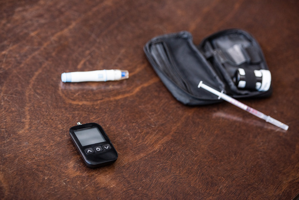 selective focus of glucose monitor near blood lancer on table  - Photo, Image
