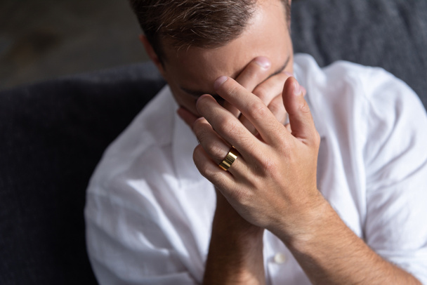depressed man with ring crying  and covering face with hands at home - Foto, afbeelding