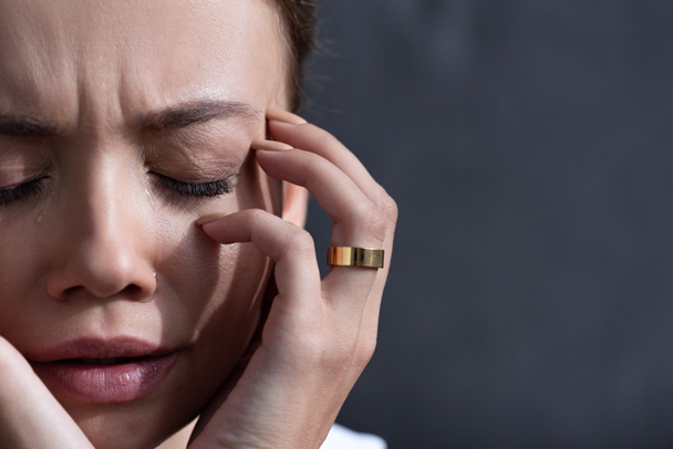 μερική θέα της αναστατωμένα νεαρή γυναίκα με δαχτυλίδι με κλειστά μάτια - Φωτογραφία, εικόνα