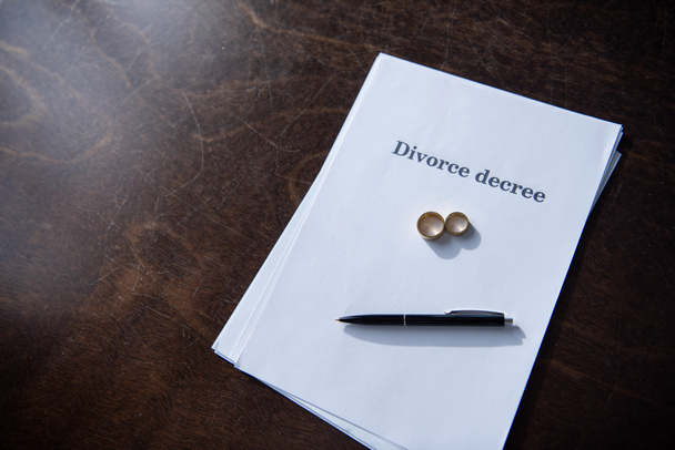 documentos de divorcio y pluma sobre mesa de madera marrón
 - Foto, imagen