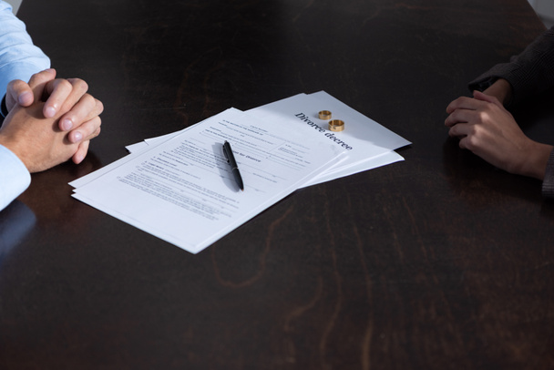 partial view of couple at table with divorce documents - Foto, imagen