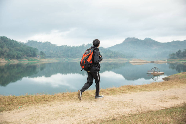 travelers with backpacks overlooking enjoy lake view - Photo, Image