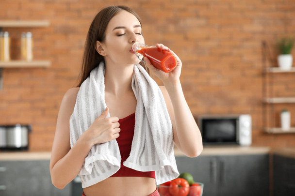 Fiatal sportos nő iszik egészséges zöldséglevet a konyhában - Fotó, kép