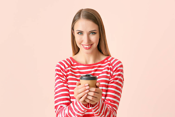 Krásná mladá žena s šálkem kávy na barevném pozadí - Fotografie, Obrázek