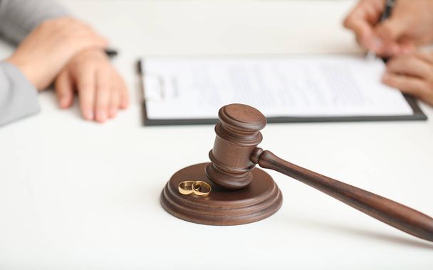 Судья молоток и кольца на столе в офисе адвоката. Концепция развода
 - Фото, изображение