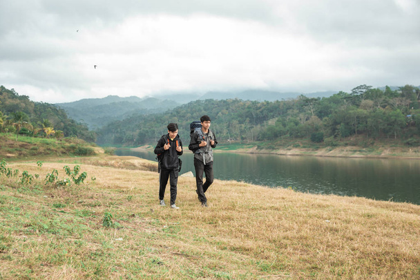 Two asian travelers standing near lake - Φωτογραφία, εικόνα