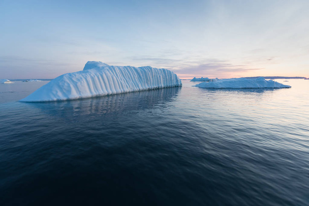 Hatalmas jéghegyek különböző formákban a Disko Bay-ben, Nyugat-Grönlandon. A forrásuk a Jakobshavn gleccser. Ez a globális felmelegedés és a katasztrofális jégolvadás következménye.  - Fotó, kép