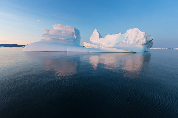Enormes icebergs de diferentes formas en la bahía de Disko, al oeste de Groenlandia. Su origen es por el glaciar Jakobshavn. Esto es consecuencia del fenómeno del calentamiento global y el deshielo catastrófico del hielo.
  - Foto, Imagen