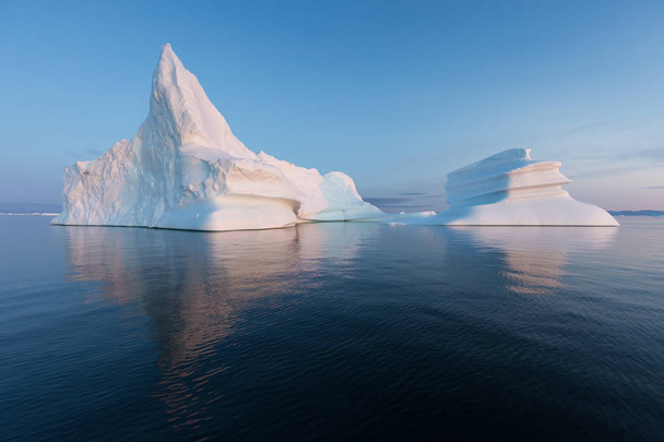 Enormes icebergs de diferentes formas en la bahía de Disko, al oeste de Groenlandia. Su origen es por el glaciar Jakobshavn. Esto es consecuencia del fenómeno del calentamiento global y el deshielo catastrófico del hielo.
  - Foto, Imagen
