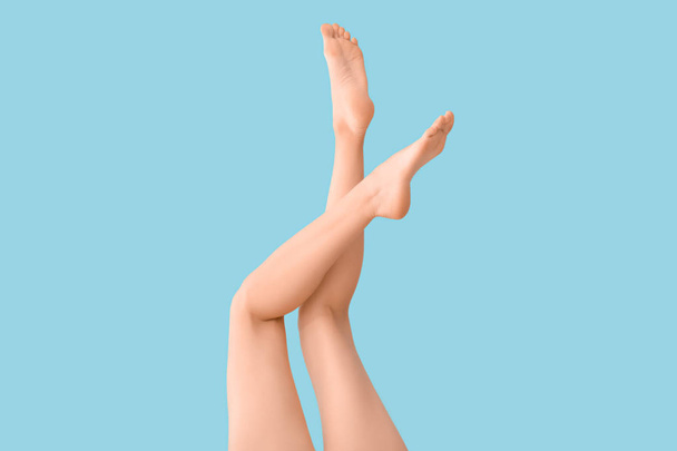 Legs of beautiful young woman on color background - Photo, image