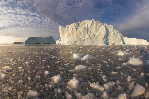 Obrovské ledovce různých forem v Disko Bay, Západní Grónsko. Jejich zdroj je u Jakobshavnského ledovce. To je důsledek fenoménu globálního oteplování a katastrofálního tání ledu  - Fotografie, Obrázek